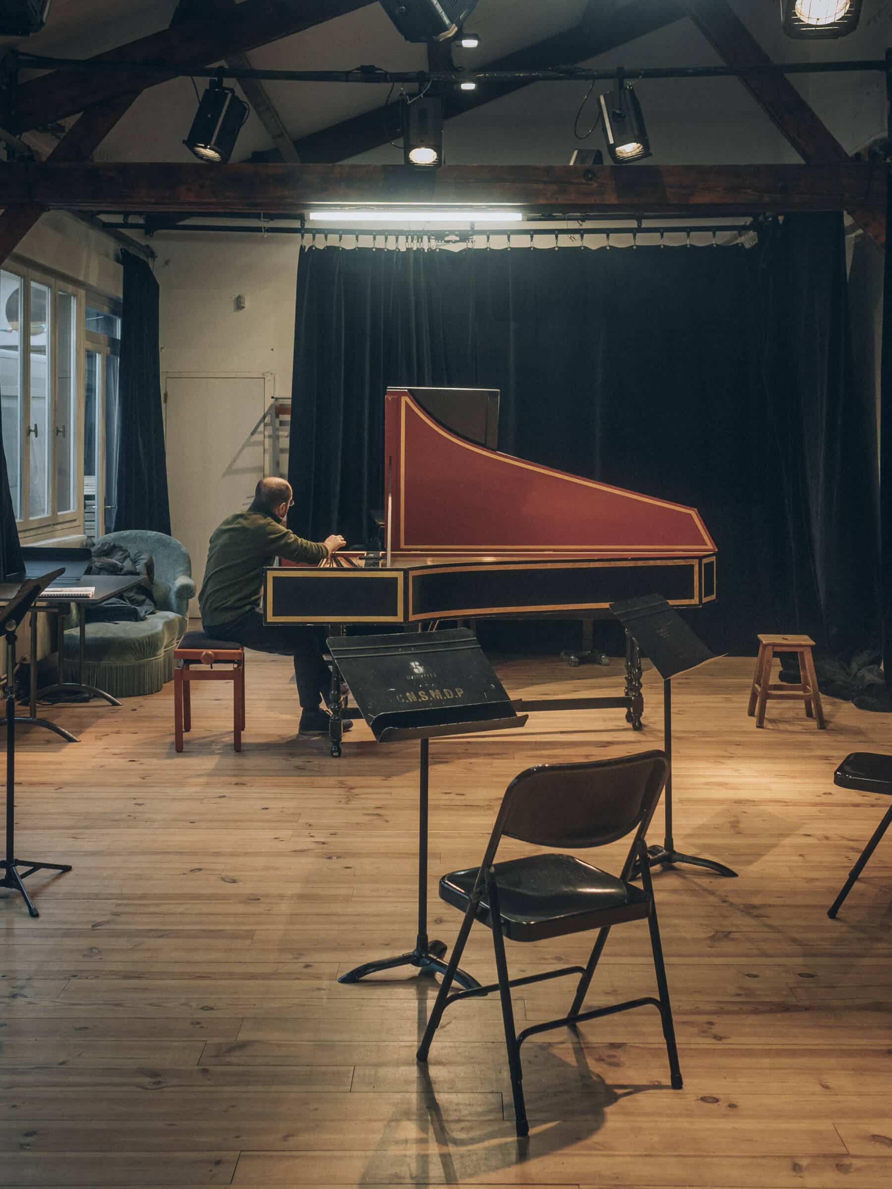 Un studio de répétition de l'Arcal, avec pupitres, clavecin, chaises, et parquet